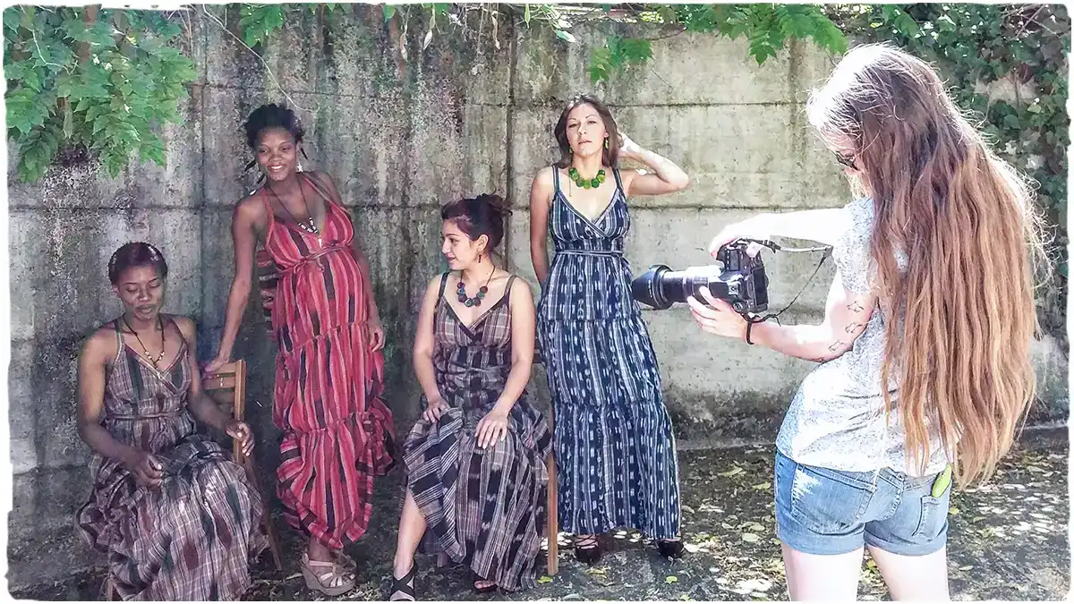 Abiti bohémien e moda: giovane fotografa scatta fotografia a un gruppo di ragazze con abiti lunghi estivi