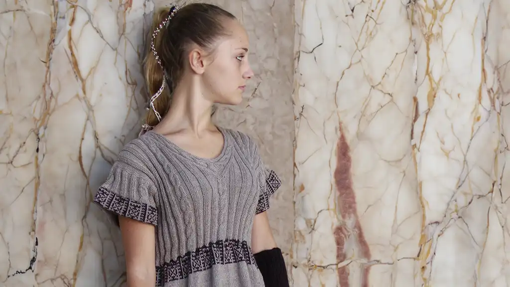 Abiti bohémien invernali: bella ragazza bionda con uno splendido abito a mezza manica realizzato in lana di alpaca