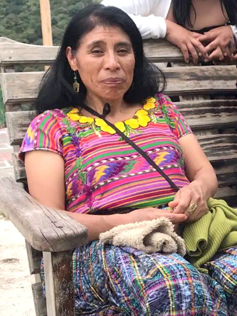 Abbigliamento estivo: donna guatemalteca con vestito tipico, seduta su una panchina