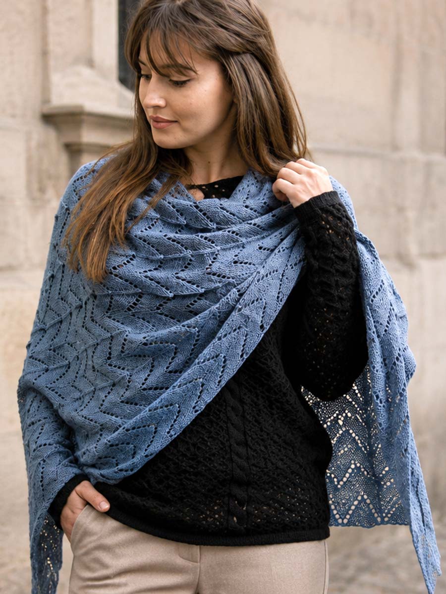 Maglieria leggera autunno con scialle blu Donna con maglioncino nero traforato e scialle blu in un outfit autunnale