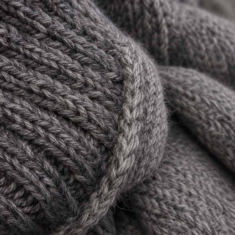 Maglione in alpaca con filato 3/10 a filo doppio Primo piano di maglia grigia in alpaca con filato 3/10 a filo doppio