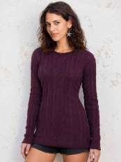 Giovane donna con maglione lungo a trecce color uva scuro in lana di alpaca, linea morbida e aderente al corpo, modello Zora.