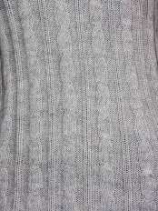 Primo piano sulla lavorazione a treccia, alpaca 100%, colore grigio chiaro: lavorazione artigianale del maglione modello Zora.